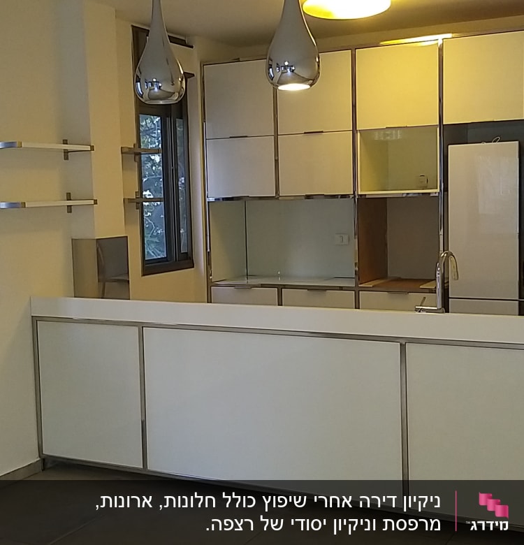 מטבח נקי עם משטחי עבודה לבנים וברז נירוסטה